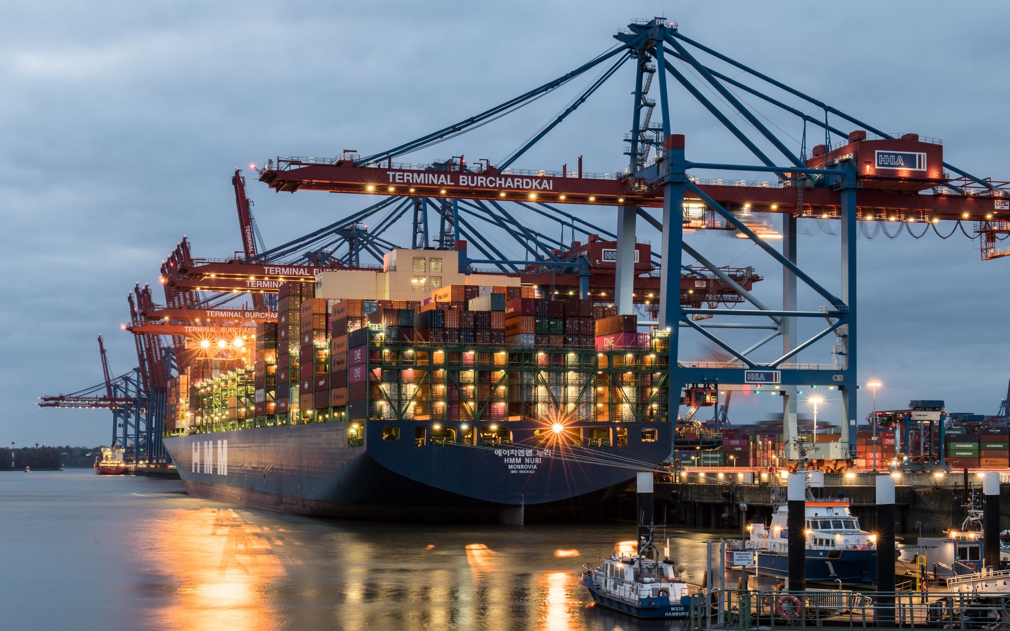 Container ship loading at a port terminal at dusk